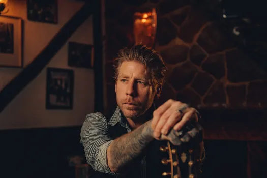 Porträttbild på artisten Jay Smith med sin gitarr. 